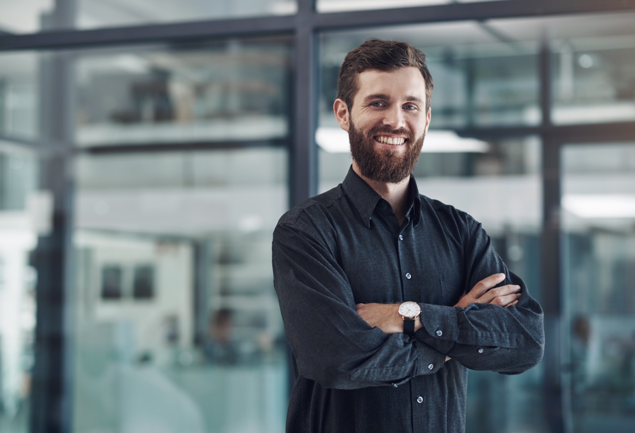 Portrait of a young businessman standing with his arms crossed in an office